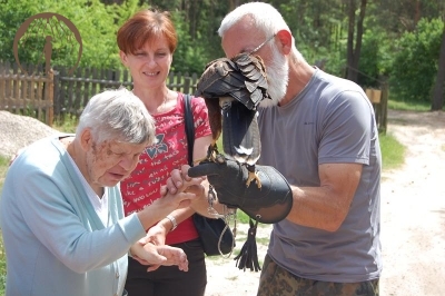 Ośrodek edukacji ekologicznej Muzeum Podlaskiego, Pani Jadwiga i Pani Dorota dotykają Sokoła trzymanego przez sokolnika na ręku