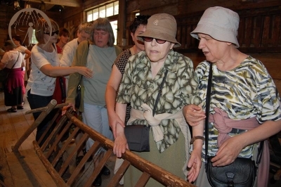 Podlaskie Muzeum Kultury Ludowej, wnętrze starej stodoły, Pani Janina i Pani Urszula oglądają wóz drabiniasty