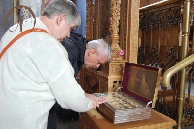 Wnętrze Prawosławnego Monastyru Zwiastowania Przenajświętszej Bogurodzicy w Supraślu, ks. Antoni i Pani Stanisława pochylają się nad relikwiarzem