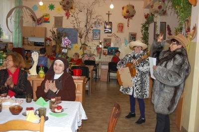 WTZ, z prawej strony Zespół Futrzaki śpiewa Pani Majce okolicznościową piosenkę, z lewej strony przy stole siedzi Pani Majka i s. Kinga