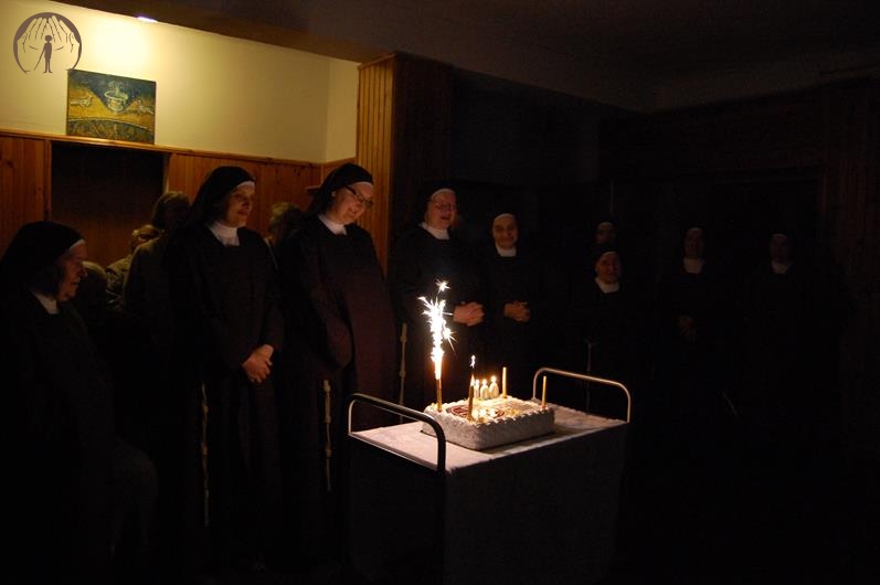 Hol przed Kaplicą w Domu Nadziei, Siostry i Wspólnota Żułowa oglądają okolicznościowy tort z płonącymi świecami