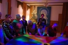Świetlica Domu Nadziei, Bal Sylwestrowy, Mieszkanki i Uczestnicy WTZ stojąc w okręgu trzymają kolorową okrągłą chustę animacyjną