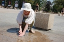 Pani Anna łapie strumienie wody z małej fontanny na lubelskim deptaku