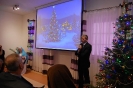 Sala muzykoterapii, pan Paweł Kacprzyk Prezes TOnOS zwraca się do Zgromadzonych, na ekranie wyświetlony obraz świątecznej choinki
