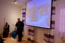 Sala muzykoterapii, pan Waldemar Fedorowicz Dyrektor PCPR w Krasnymstawie zwraca się do Zgromadzonych, na ekranie wyświetlony obraz świątecznej choinki