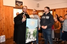 Hol przed Kaplicą Domu Nadziei, ks. Michał trzyma obraz i stroik świąteczny otrzymany od p. Krzysztofa i p. Piotra