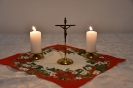 Ołtarzyk kolędowy, krucyfiks, zapalone świece